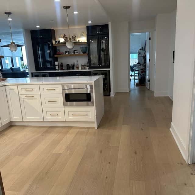Cleaned white kitchen island and wide-plank oak floor looking through to the living area — Ferrer Cleaning, Chicago, IL