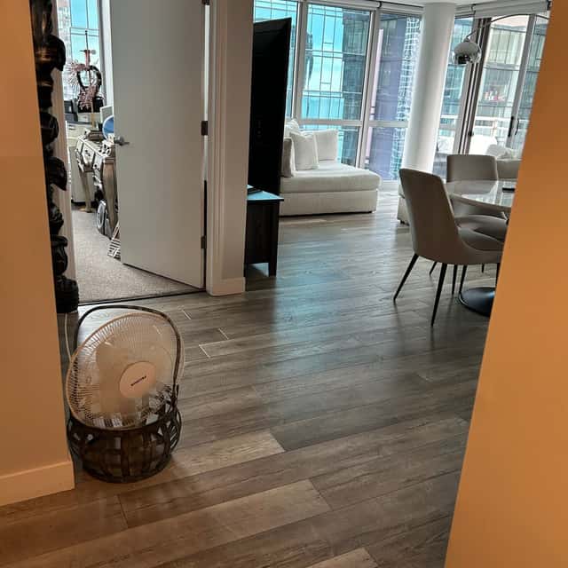 Doorway view into a cleaned condo living room with a dining table and city windows — Ferrer Cleaning, Chicago, IL