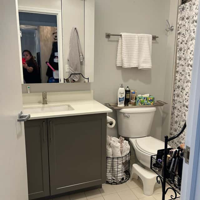 Bathroom with a grey vanity, folded towels on a rail and a cleaned toilet — Ferrer Cleaning, Chicago, IL