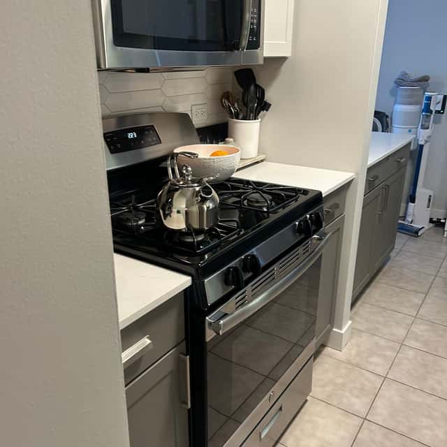 Stainless gas range and white subway-tile backsplash cleaned in a galley kitchen — Ferrer Cleaning, Chicago, IL