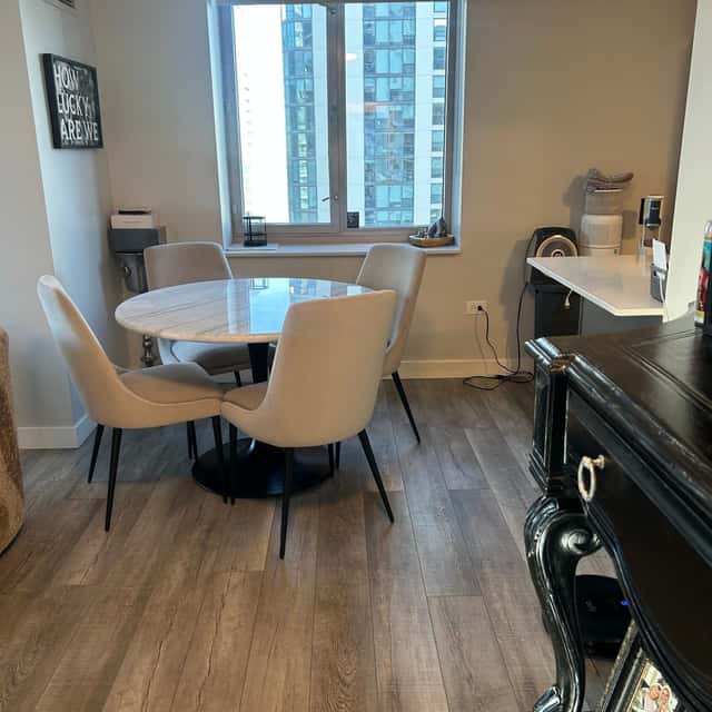 Round white dining table and chairs by the window of a cleaned high-rise apartment — Ferrer Cleaning, Chicago, IL