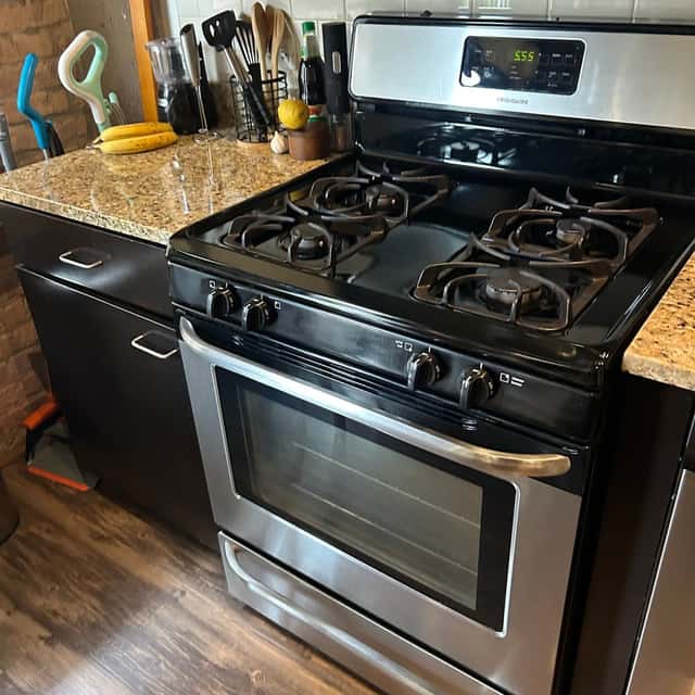 Stainless gas range and granite counters wiped down after a kitchen clean — Ferrer Cleaning, Chicago, IL