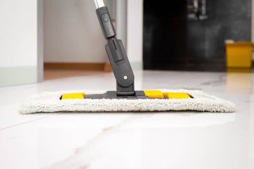Microfiber mop cleaning a polished marble floor during a recurring maintenance clean